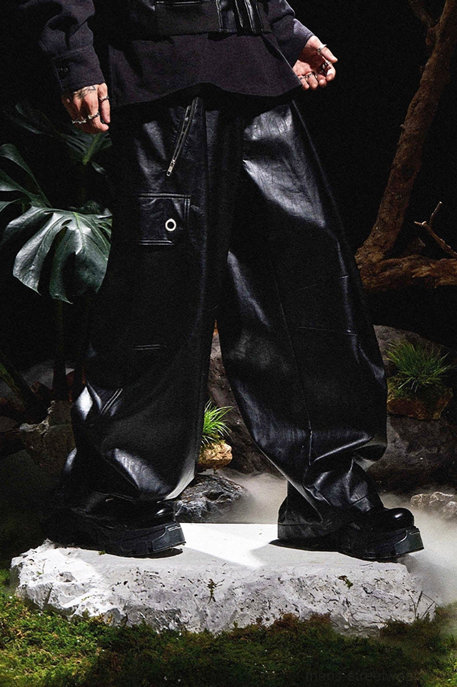 Black wide-leg faux leather cargo pants showing relaxed fit, stacked hem and contemporary Korean streetwear styling