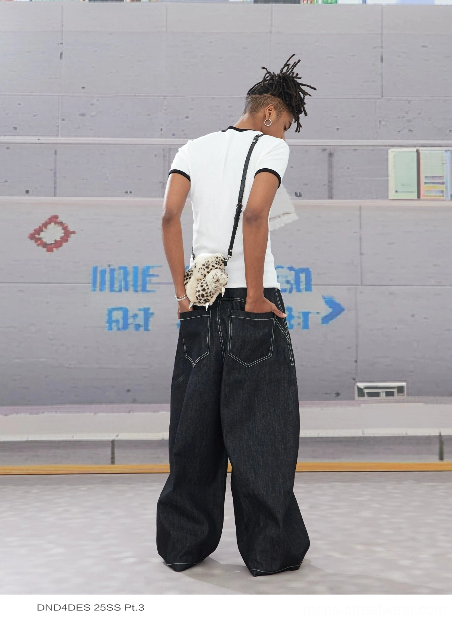 Back view of black wide leg hook closure contrast stitch jeans showing rear patch pockets and wide fit