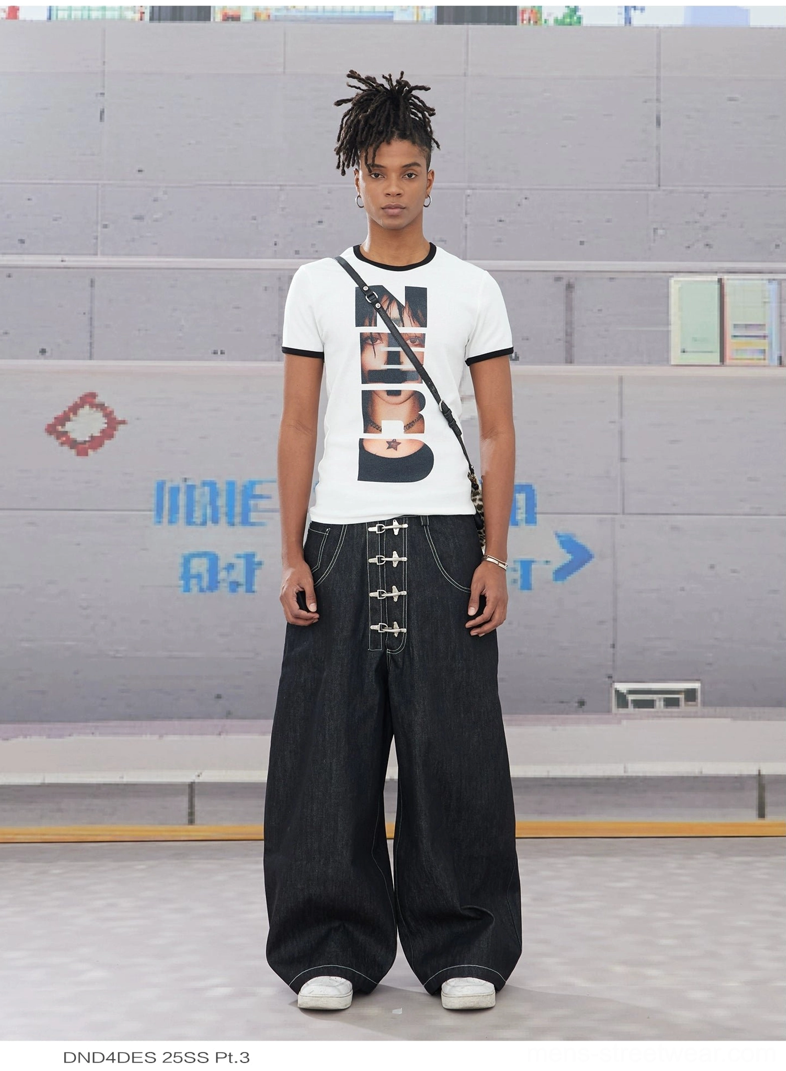 Black wide leg hook closure contrast stitch jeans front view styled with graphic white tee and crossbody bag