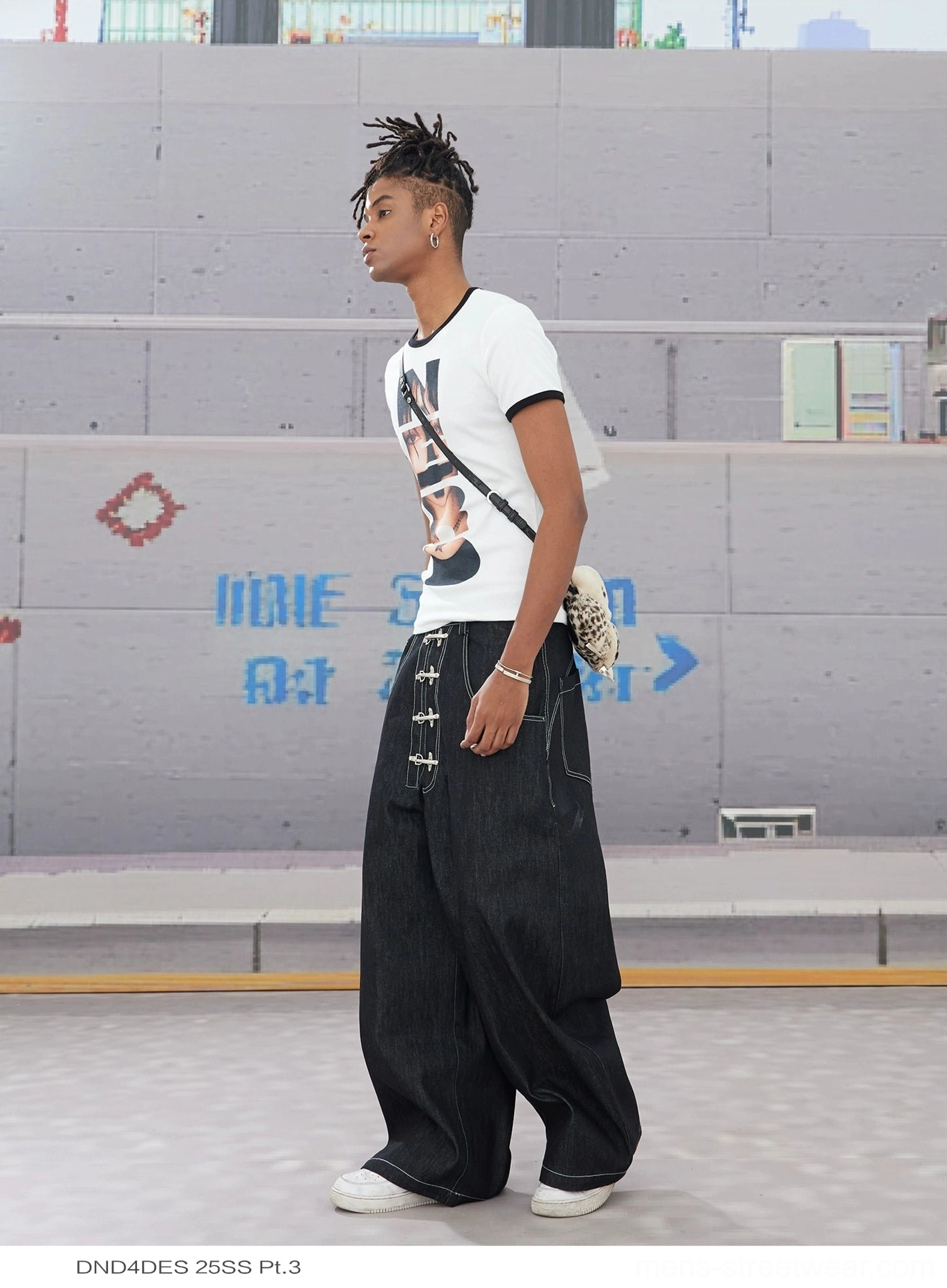 Side profile of black wide leg hook closure contrast stitch jeans showing relaxed wide leg silhouette
