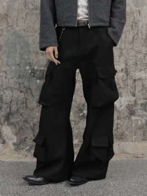 Black wide-leg multi-pocket cargo trousers styled with a grey cropped jacket and leather shoes in an industrial streetwear setting