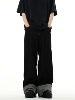 Low-angle front view of black wide-leg rolled cuff denim jeans with an oversized black t-shirt and relaxed Seoul streetwear styling