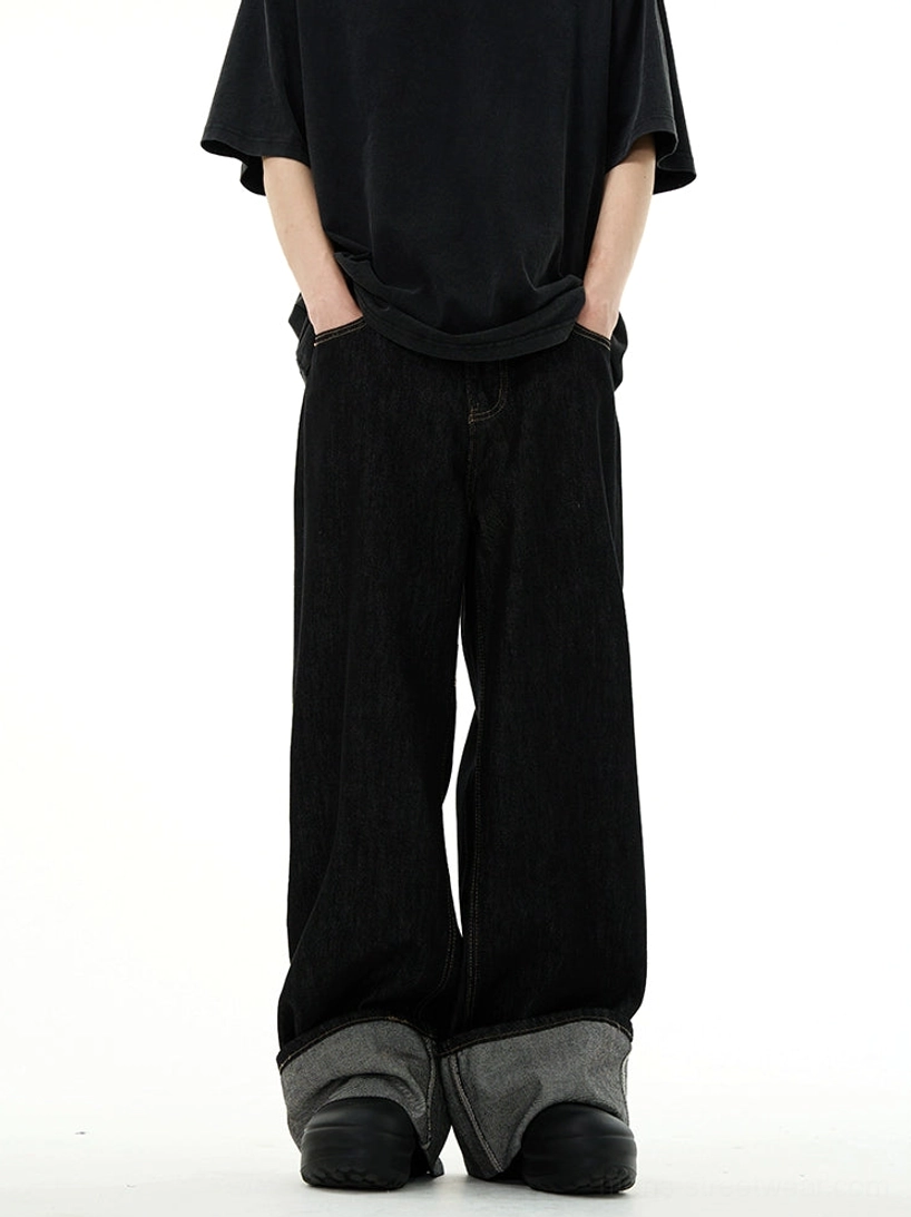 Low-angle front view of black wide-leg rolled cuff denim jeans with an oversized black t-shirt and relaxed Seoul streetwear styling