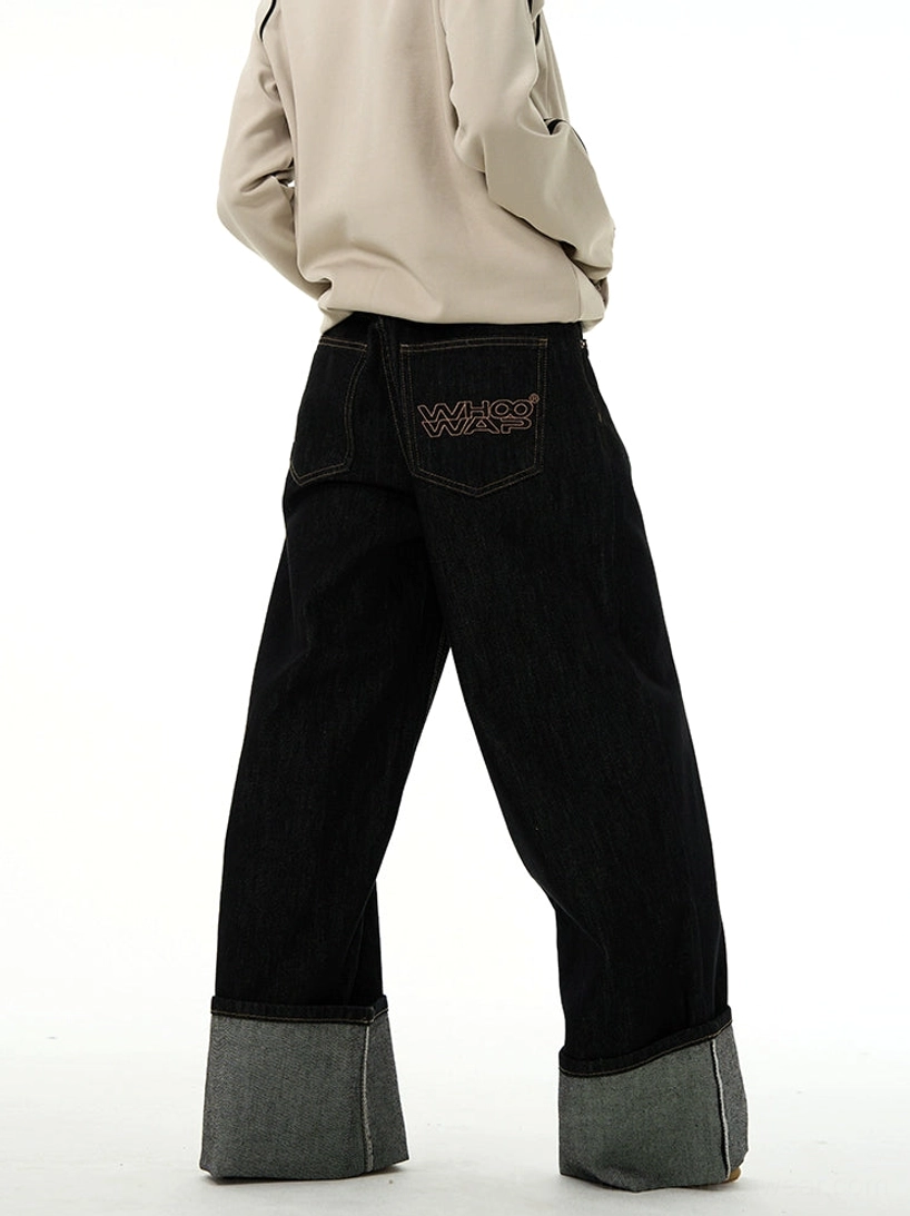 Rear full-body view of black wide-leg rolled cuff denim jeans showing five-pocket construction and extra-long relaxed fit
