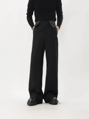 Front view of black wide-leg suit trousers with pinstripe waist and pocket accents styled with platform shoes