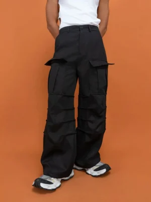 Black wide-leg techwear cargo pants shown from the rear three-quarter view with tailored waistband and large thigh flap pockets