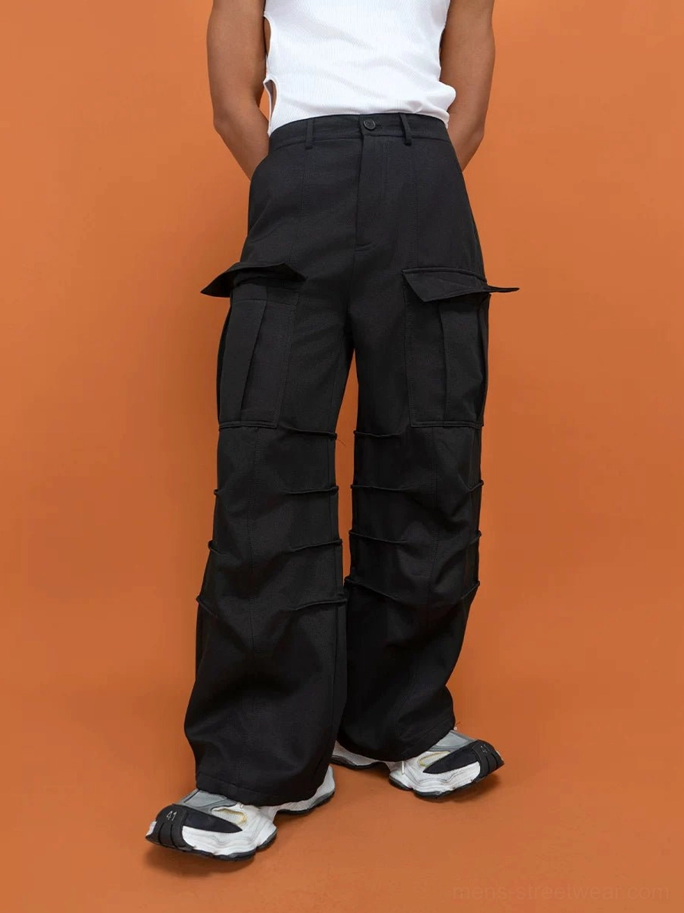 Black wide-leg techwear cargo pants shown from the rear three-quarter view with tailored waistband and large thigh flap pockets