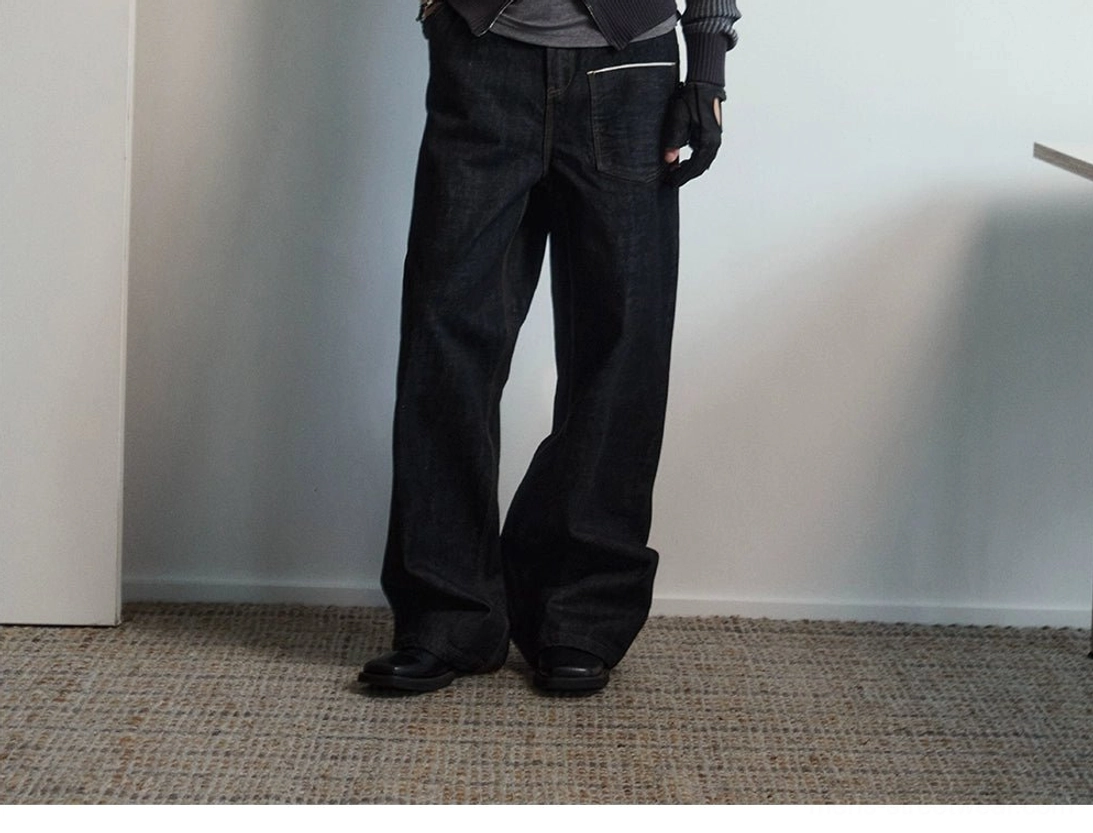 Rear three-quarter view of black wide leg denim utility jeans featuring back pocket contrast stitching and long loose legs