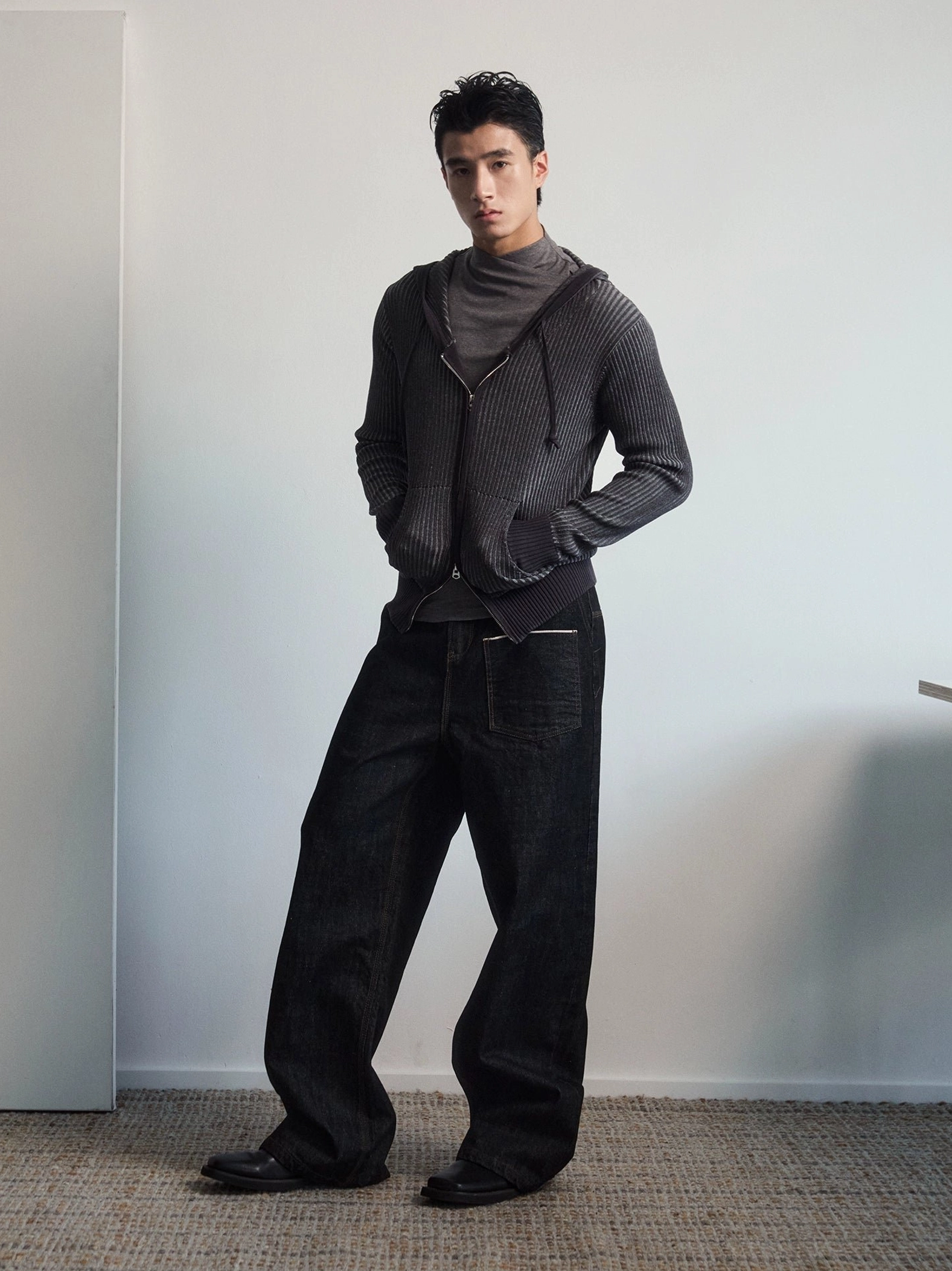 Black wide leg utility jeans with contrast stitching shown in a front three-quarter full-body streetwear outfit