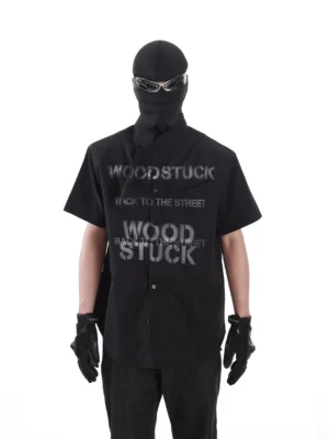 Black Woodstuck graphic asymmetric collar short sleeve streetwear shirt front view with Back to the Street print
