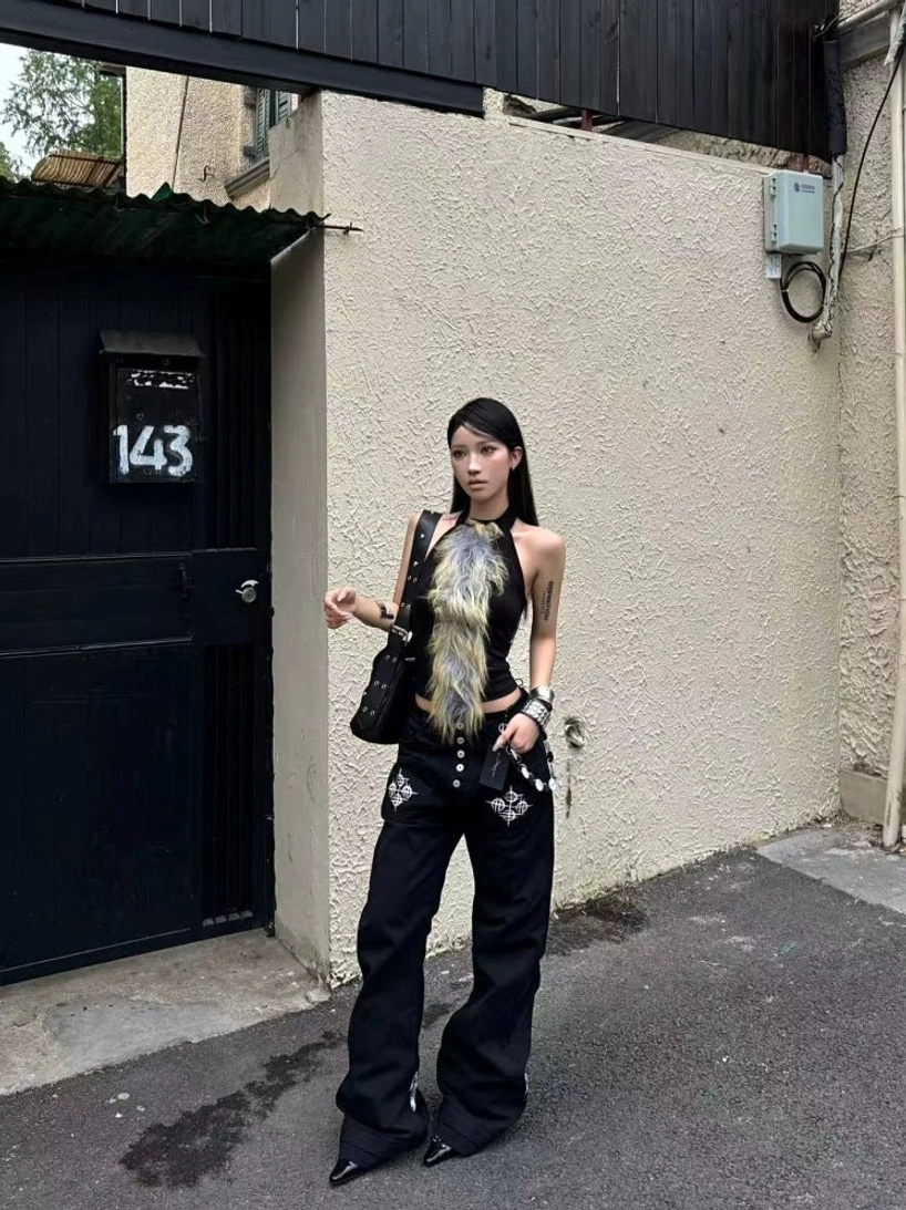 Front view of black Y2K flare jeans with studded pockets styled in a punk streetwear outfit