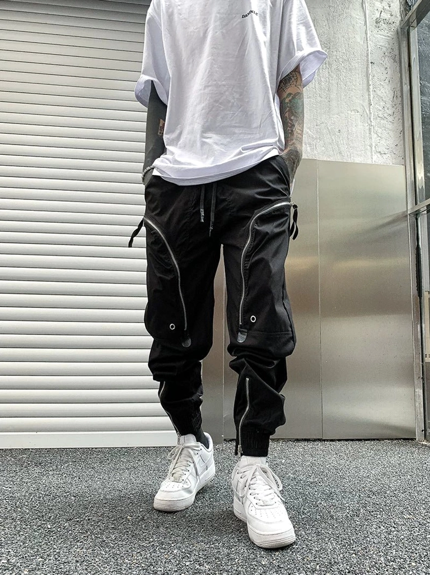 Black zippered cargo joggers front three-quarter view with metal hardware, utility pockets and tapered streetwear fit