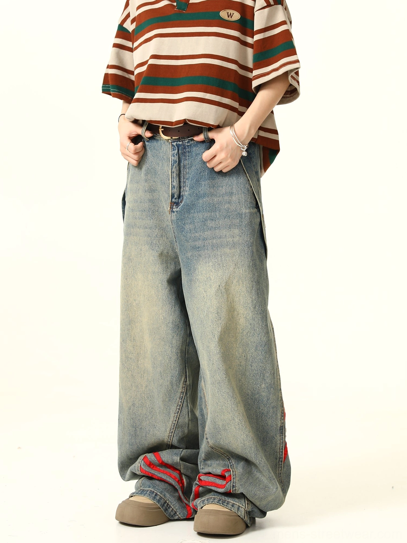 Front three-quarter view of relaxed blue baggy denim jeans with red triple stripes, button fly waistband, belt loops, and vintage light-wash finish