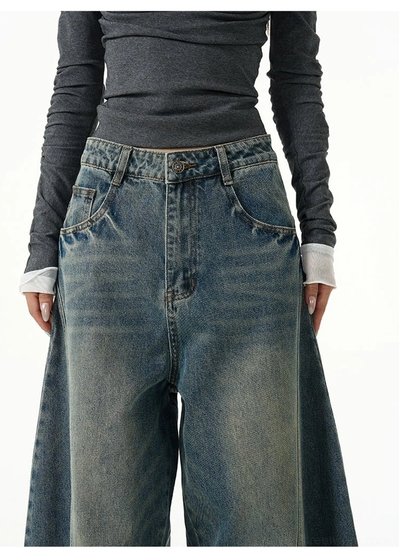 Close-up of the blue balloon jeans waistband showing button fly, front pockets, and faded denim texture