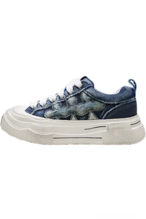 Blue denim platform casual sneaker shown in side profile with frayed flower denim appliqué, textured thick rubber outsole, rear pull tab, and low-top lace-up design