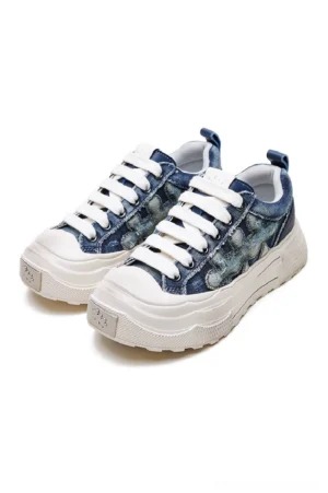 Blue denim platform sneakers shown in a three-quarter front view with washed indigo denim upper, frayed floral appliqué, white laces, metal toe detail, and chunky off-white rubber sole
