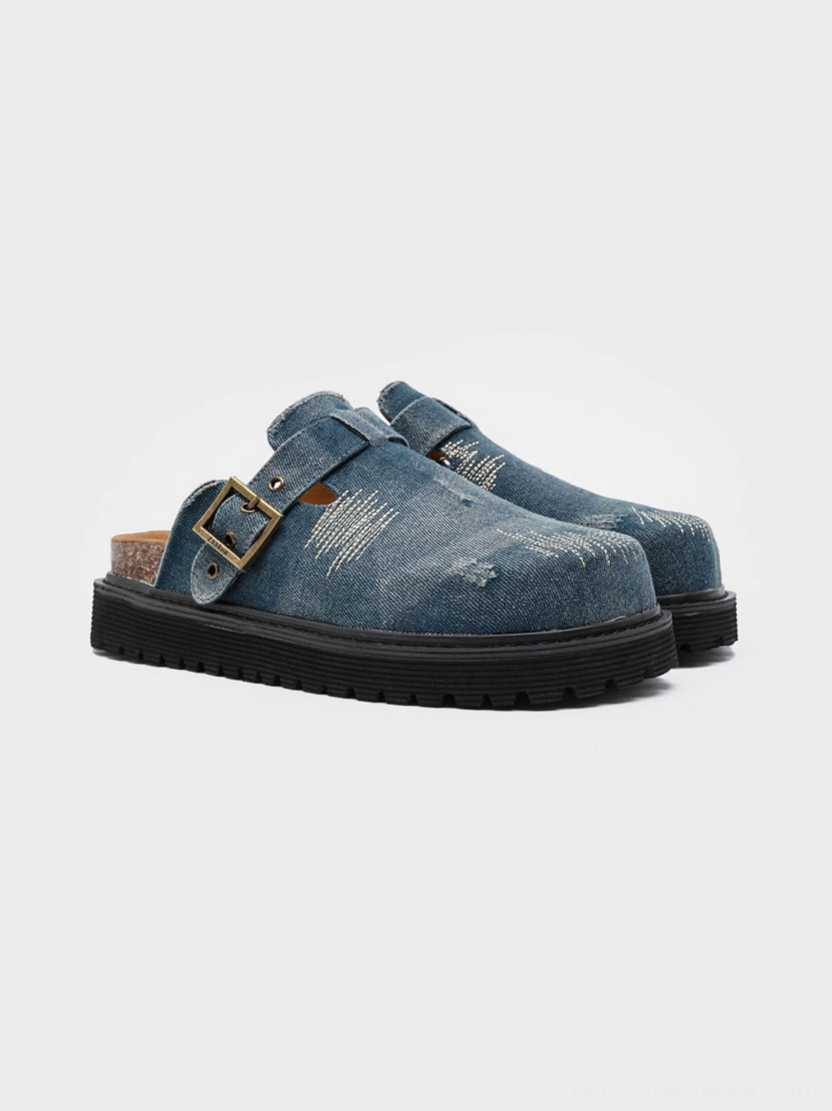 Blue distressed denim platform mule clogs with frayed texture, vintage buckle strap, cork-style footbed and chunky rubber sole on a white studio background