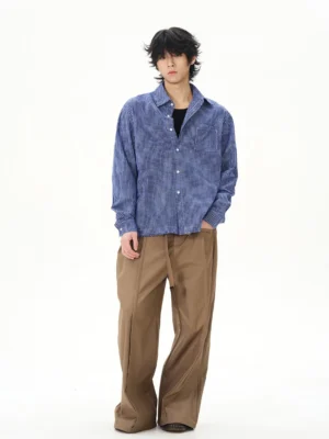 Male model wearing blue gingham long sleeve cotton shirt with brown wide leg trousers