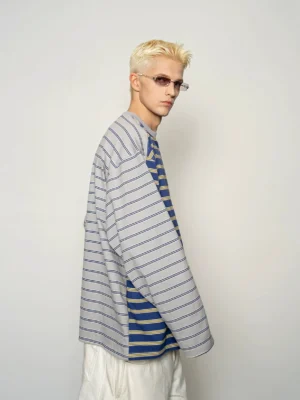 Side view of a blue green dual stripe long sleeve sweatshirt showing contrasting body and sleeve stripe patterns drop shoulder construction and ribbed cuffs
