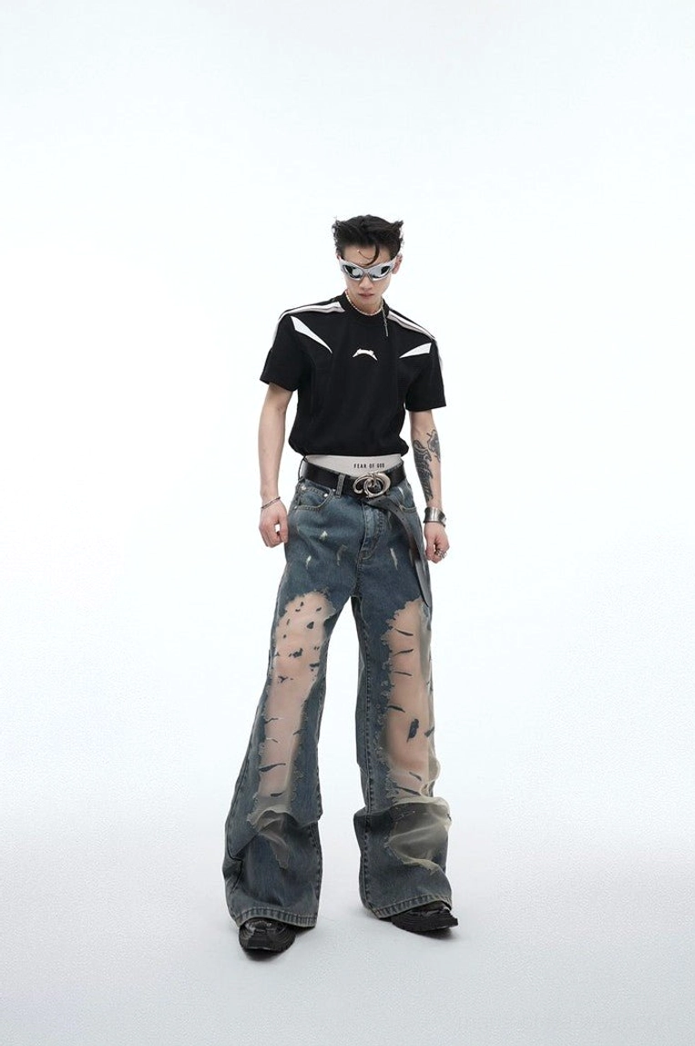 Full front view of blue mesh panel distressed wide leg jeans styled with sunglasses and a streetwear tee