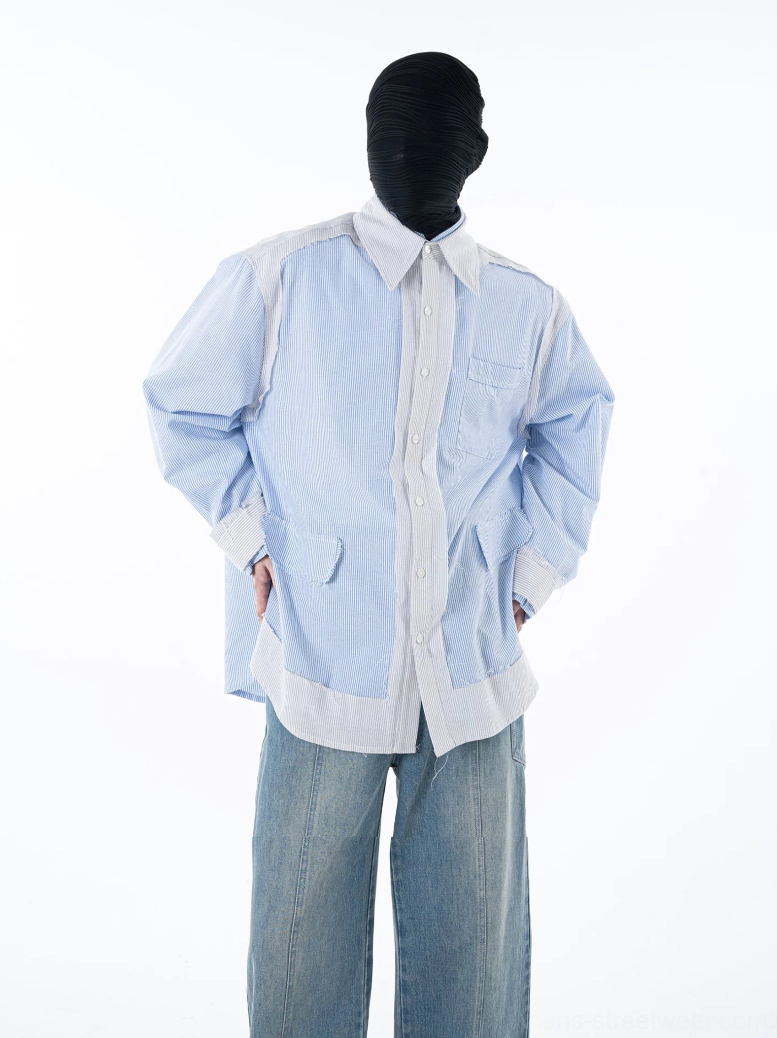 Rear three-quarter view of a blue pinstripe overshirt with contrast white hem relaxed long sleeves and wide-leg denim streetwear styling