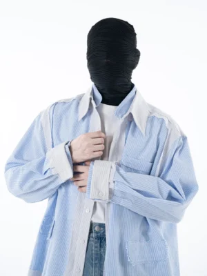 Front three-quarter view of a blue and white pinstripe oversized streetwear overshirt with contrast white collar cuffs patch pockets and relaxed dropped shoulders