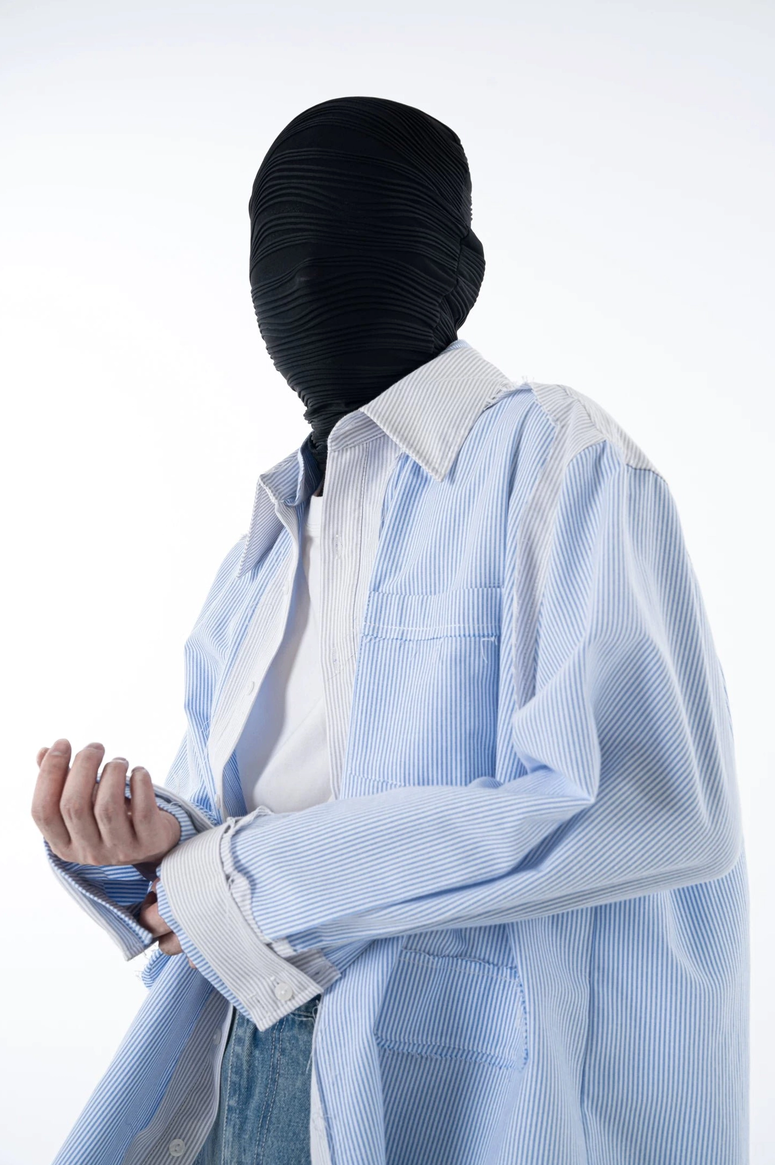 Low angle side view of a relaxed long sleeve blue pinstripe streetwear overshirt with contrast white collar and cuffs
