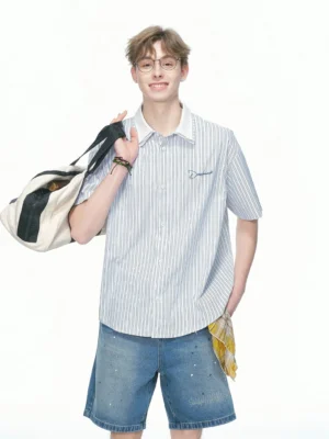 Blue pinstripe Korean streetwear shirt with chest embroidery styled with distressed denim shorts canvas duffle bag and waist handkerchief