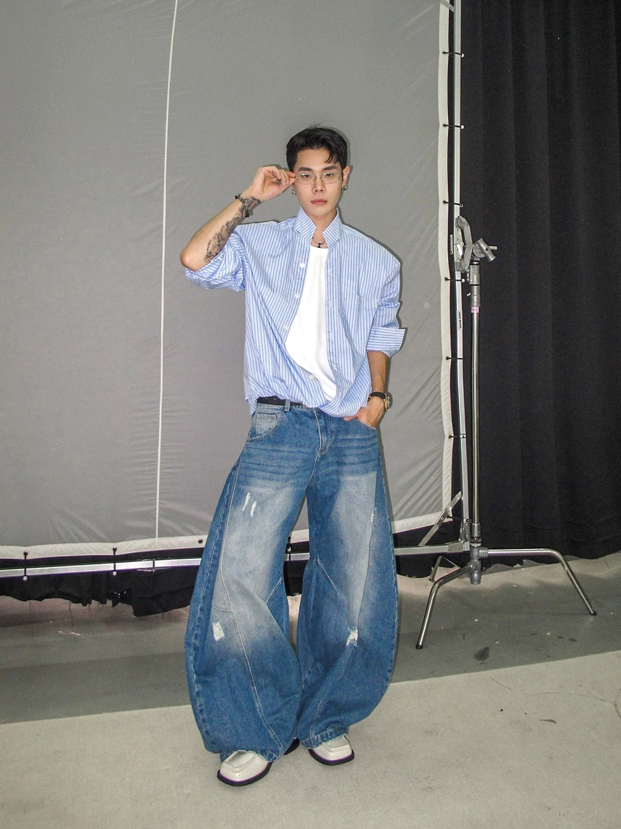 Blue pinstripe stand collar long sleeve shirt in side profile with half-tucked Korean streetwear styling