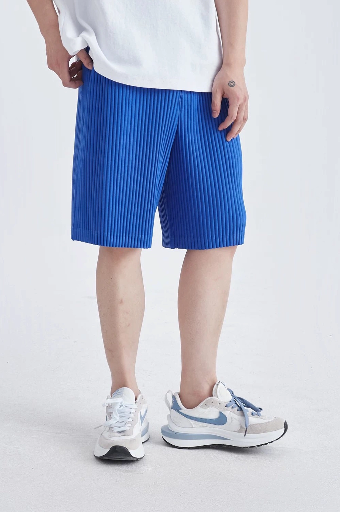 Blue pleated tech shorts with relaxed straight legs for contemporary Korean streetwear styling