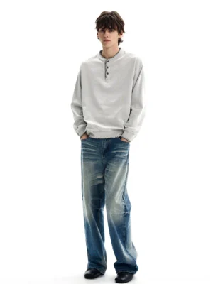 Relaxed blue Henley sweatshirt with drop shoulders styled with washed straight-leg jeans