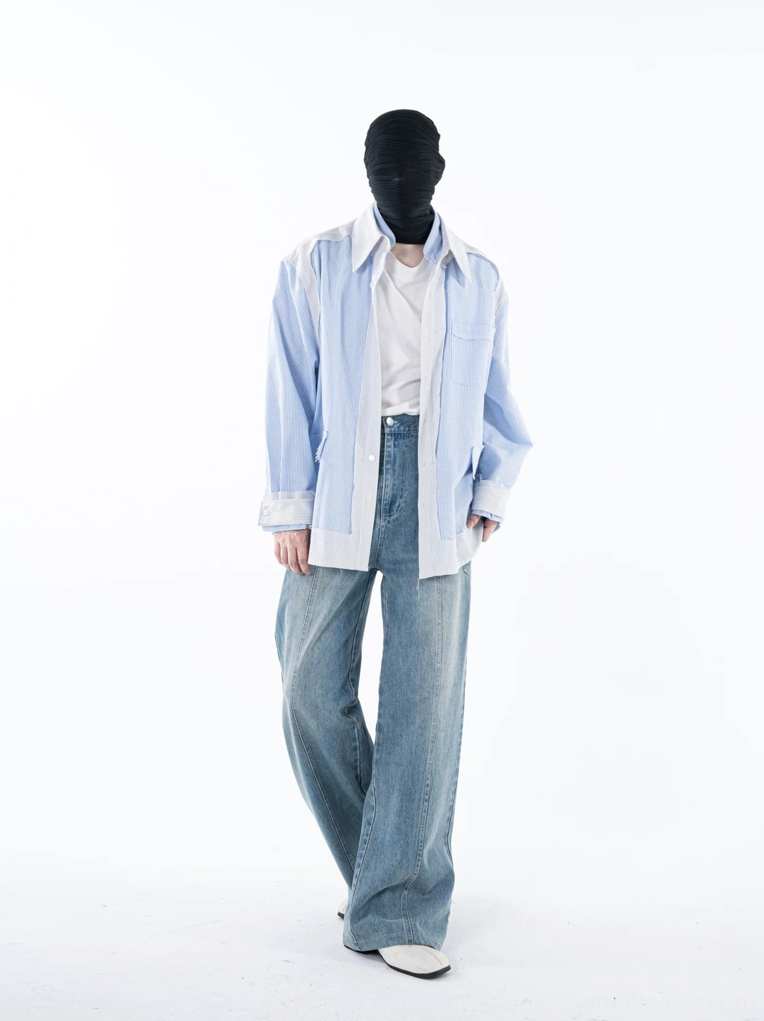 Front walking view of a blue and white color-blocked pinstripe overshirt styled with denim jeans and casual white sneakers