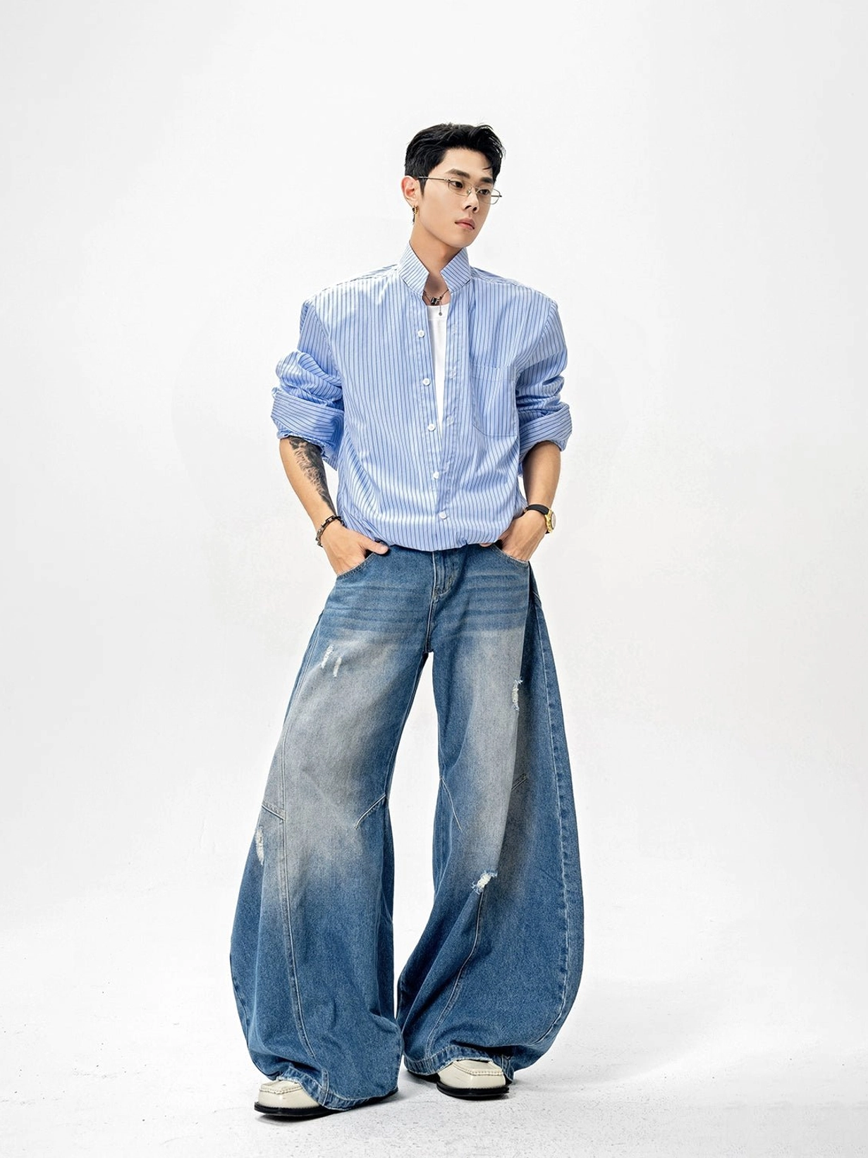 Blue and white vertical pinstripe stand collar shirt styled with white tee and distressed wide-leg jeans