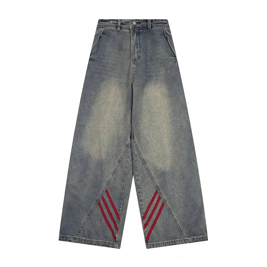 Flat lay view of blue wide-leg denim jeans with red triple-stripe accents at the outer leg seams, waistband, pockets, and vintage wash
