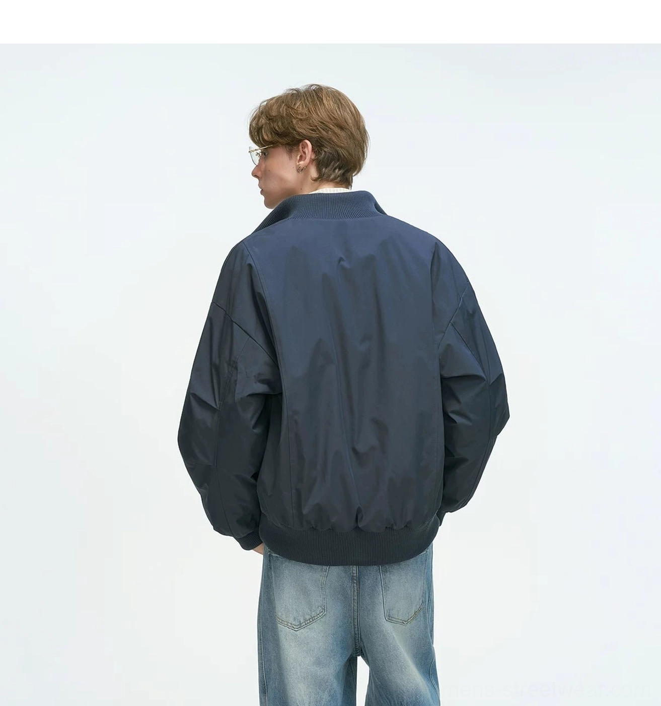 Bomber jacket fabric close-up showing polyester shell texture, weather-resistant outer material and solid color finish streetwear quality