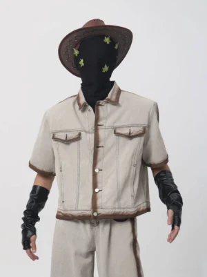 Front close up of a boxy cropped short sleeve denim jacket with brown burnished edging button placket and dual chest flap pockets