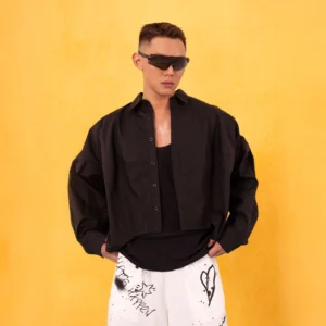 Black oversized cropped poplin button-up shirt layered over a black tank top in minimalist Seoul streetwear styling