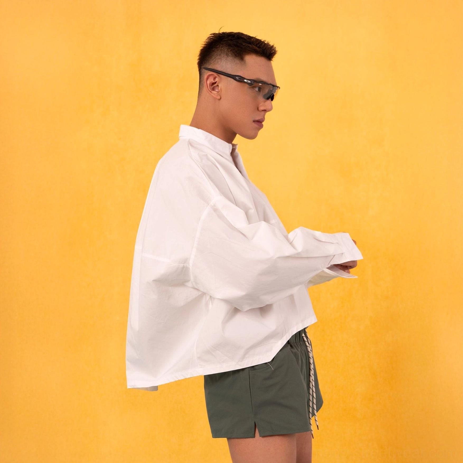 White boxy oversized cropped poplin shirt with dropped shoulders and wide sleeves on a male model in Korean streetwear style