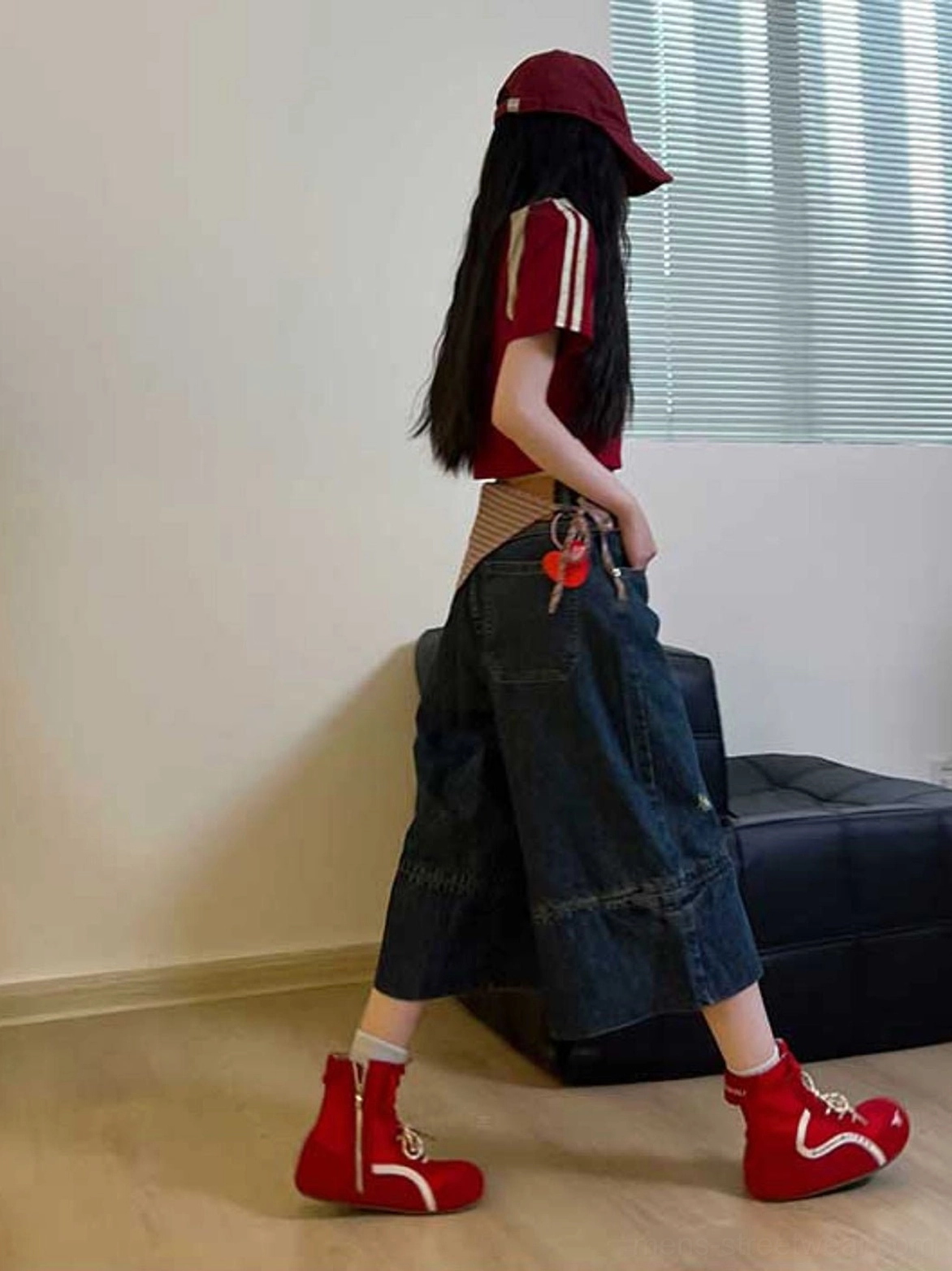 Bright red high-top racing boots styled with wide-leg denim and casual streetwear clothing in an urban fashion look