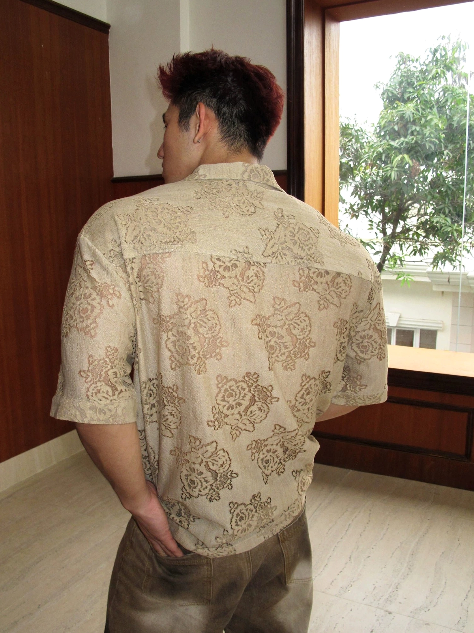 Back view of men's brown baroque floral sheer short sleeve shirt showing full pattern coverage and loose silhouette