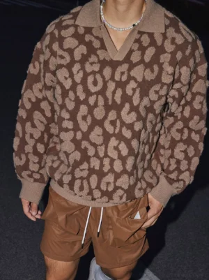 Close-up of brown and beige leopard print polo collar sweater with ribbed trims, relaxed oversized fit, and modern Seoul streetwear styling