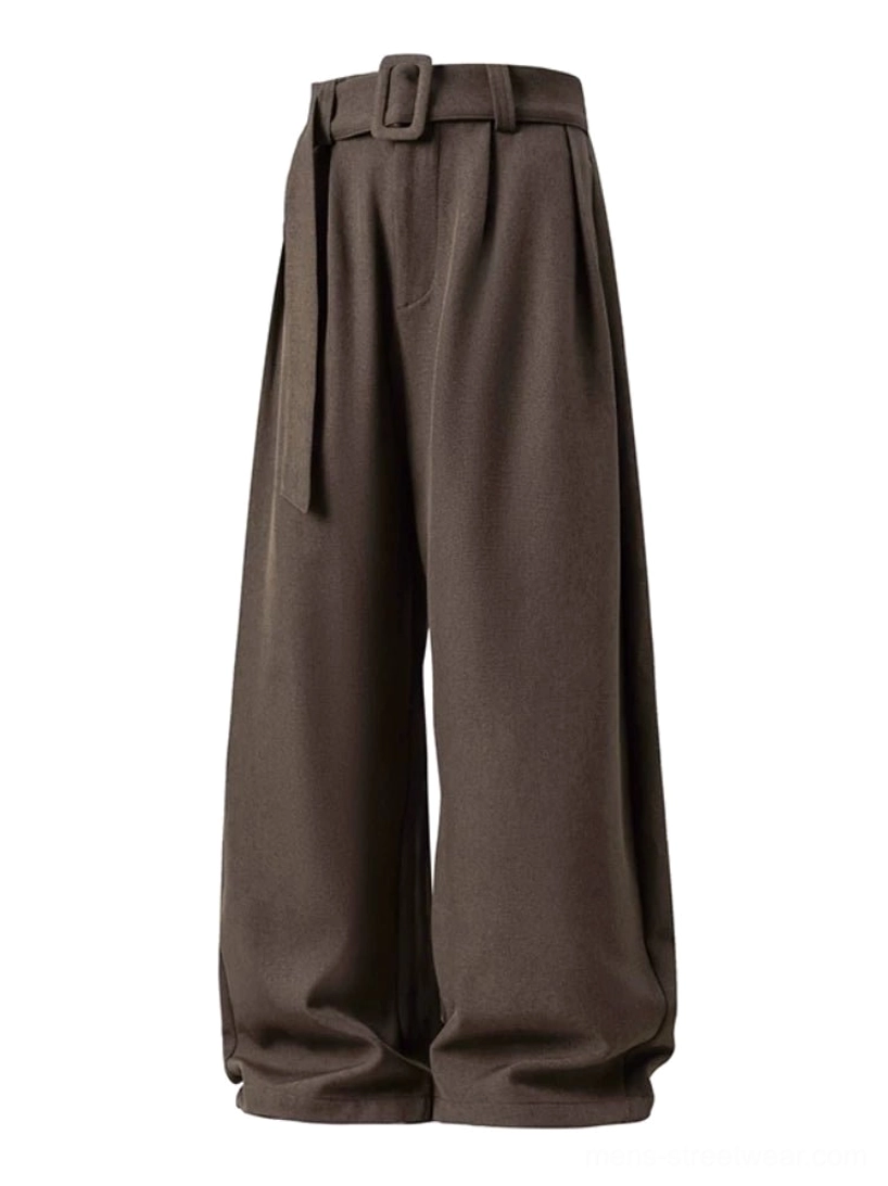 Flat lay view of brown belted wide-leg trousers featuring front pleats, curved legs, full-length drape, and relaxed men's streetwear styling