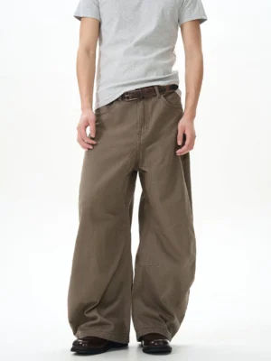 Brown wide leg denim skater pants shown in a full front view with a high waist, ultra loose silhouette, washed finish, grey t shirt, and brown loafers