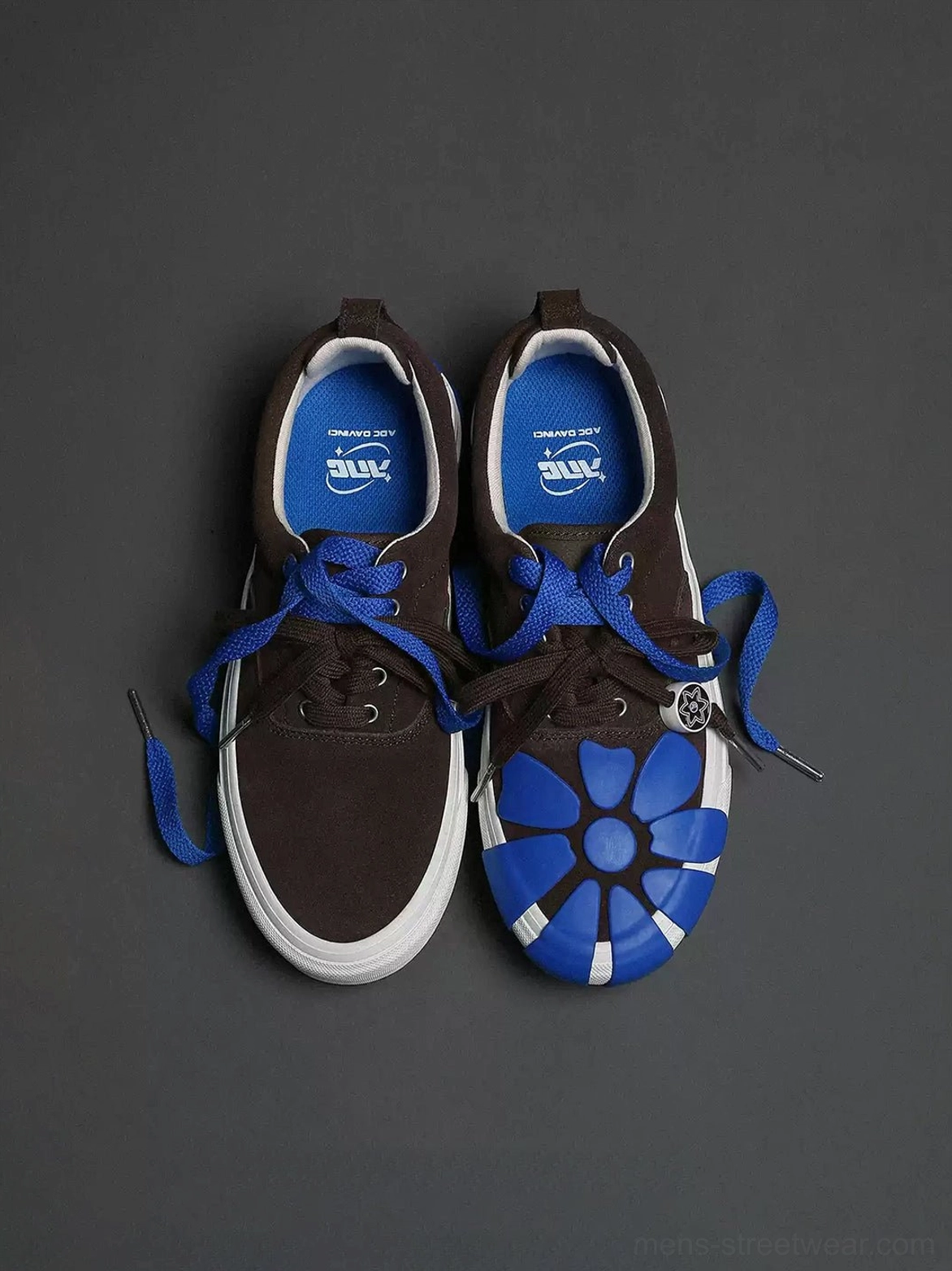 Flat lay of brown suede platform sneakers with blue floral toe caps, loose double laces, metal lace charm, and blue insoles