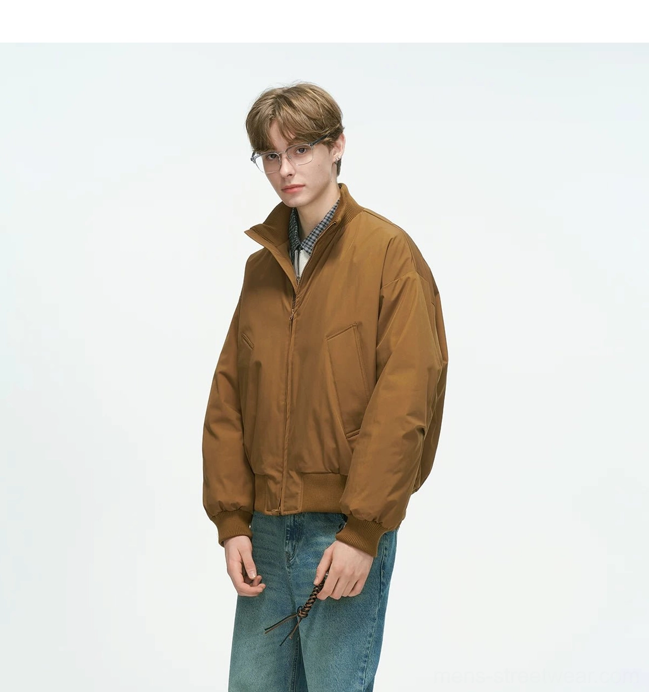 Tan brown bomber jacket three-quarter front shot featuring drop-shoulder design, stand collar and front pockets, paired with checkered inner layers streetwear
