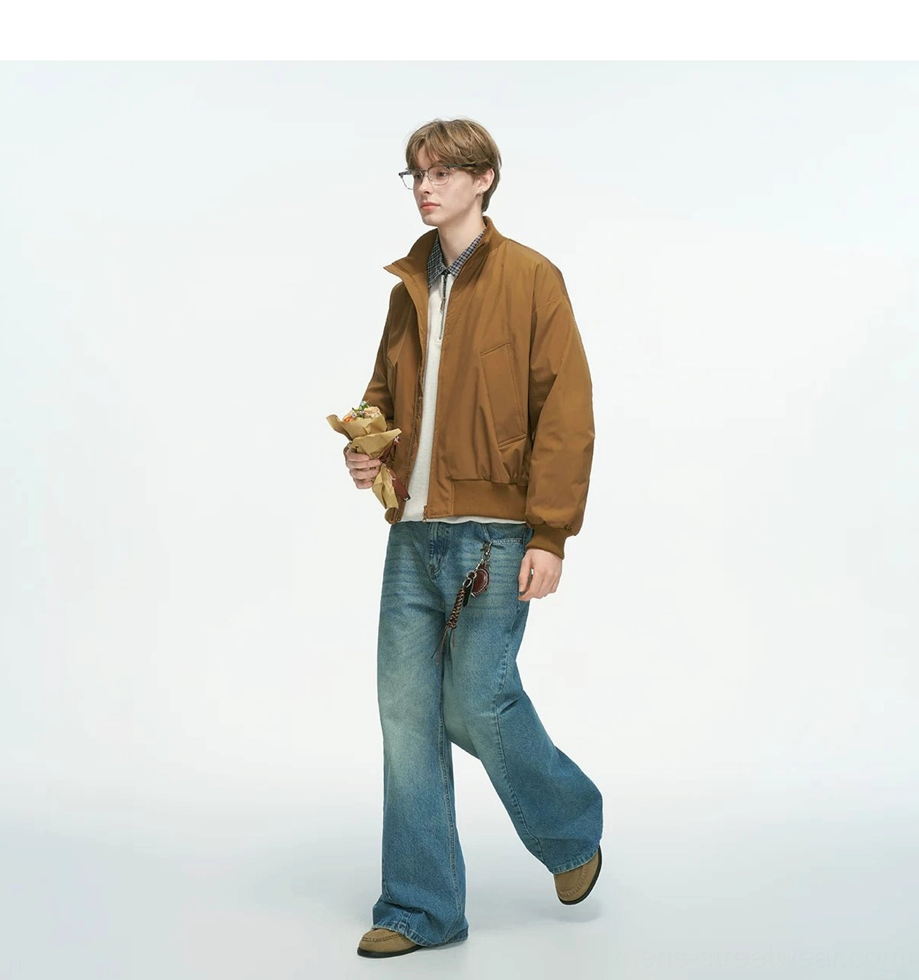 Tan brown bomber jacket full side walking shot with stand collar and ribbed hem, showing relaxed fit paired with basic inner tees and denim streetwear