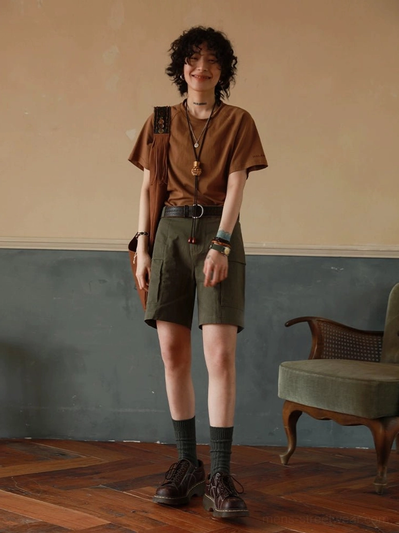 Brown relaxed boxy raglan T-shirt styled with green cargo shorts, leather belt, and boots