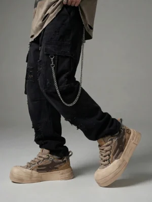Brown chunky platform sneakers styled with black ripped cargo pants and chain details in a low-angle streetwear outfit
