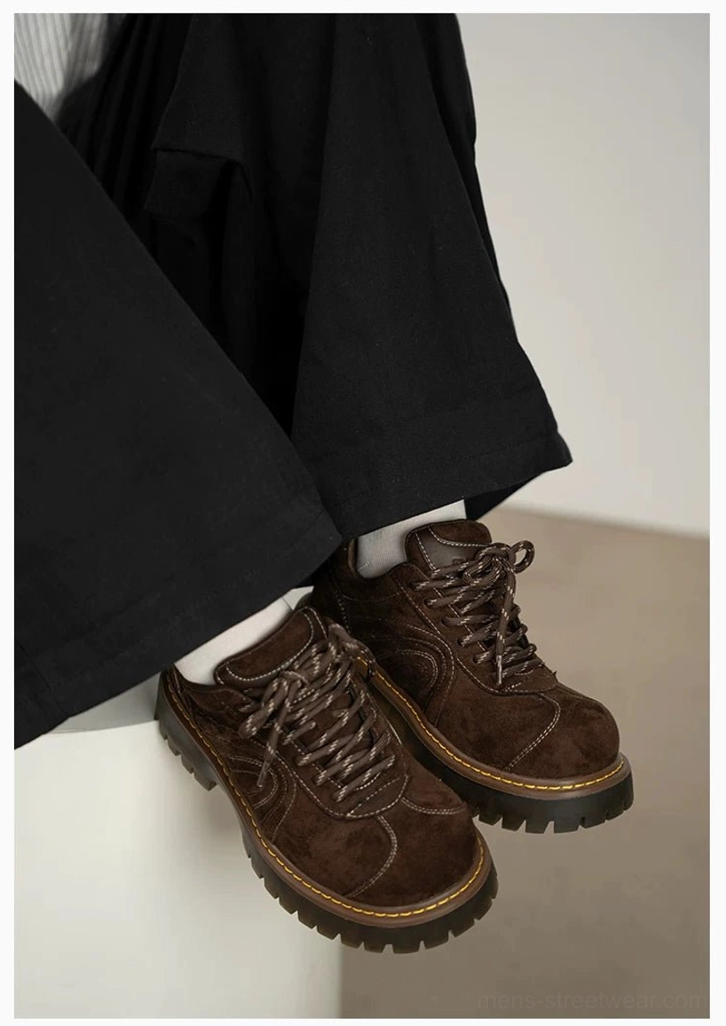 Brown chunky platform suede sneakers styled with black wide-leg pants and white socks, showing the thick rugged lug sole in a casual streetwear outfit