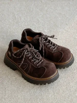 Pair of brown chunky suede-effect platform sneakers with contrast laces, yellow midsole stitching, and rugged rubber lug outsole shown from above